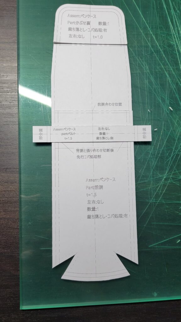 レザークラフト用の完成した型紙を重ねて間違いがないか確認している